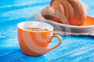 coffee cup with tasty croissant