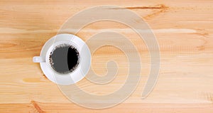 Coffee cup top view on wooden table background.