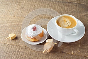 Coffee cup with traditional donuts sufganiyah for Jewish holiday Hanukkah on wooden table