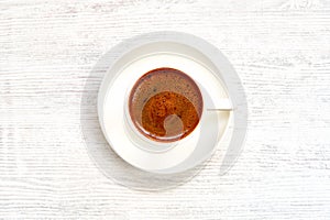 Coffee cup with turkish coffee on white wooden table . Top view