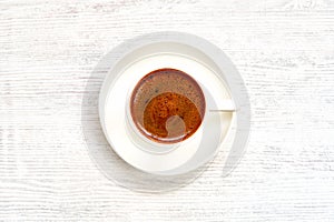 Coffee cup with turkish coffee on white wooden table . Top view photo