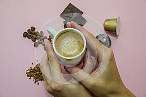 A coffee cup with a view from above, a woman`s hand holding a cup.