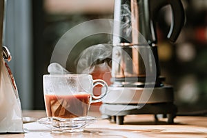 Coffee cup with vintage coffee maker moka pot background on wooden table at home office