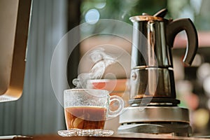 Coffee cup with vintage coffee maker moka pot background on wooden table at home office