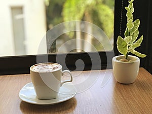 Coffee cup on wood table in coffee shop, stock photo