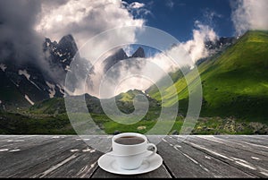 Coffee cup on wood table and view of beautiful nature background