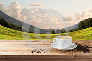 Coffee cup on wooden table over beautiful landscape background
