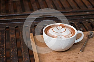 Coffee in a cup on a wooden tray at an angle