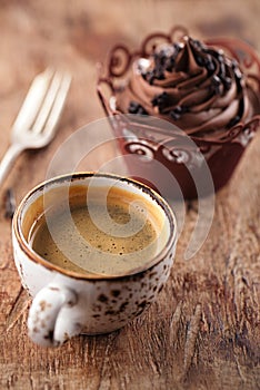 Coffee and cupcake in rustic style on wooden table