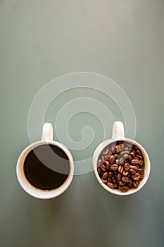 Coffee cups on green background full of coffee beans and drink