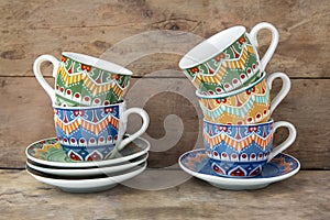 coffee cups and saucers with multicolored patterned decorations