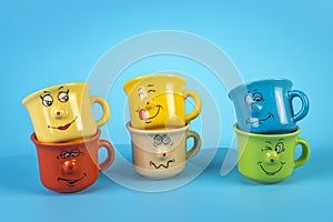 Coffee cups of various colors with funny faces