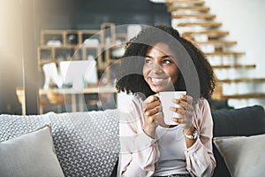 Coffee cures everything. an attractive young woman relaxing at home.