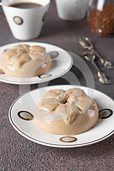 Coffee dessert made from cream and gelatin in portion molds on brown background. Dessert Blancmange