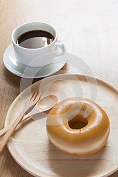 Coffee and donut in wooden dish blurred background