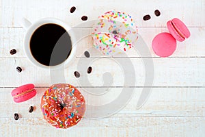 Coffee, donuts and macaroons, flat lay over white wood