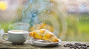 Coffee drink with croissant dessert. Enjoying coffee on rainy day. Coffee time on rainy day. Fresh brewed coffee in