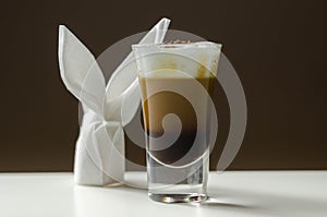 Coffee drink shot with a nutty note with fluffy milk foam, decorated with chocolate shavings, served with an Easter bunny-shaped