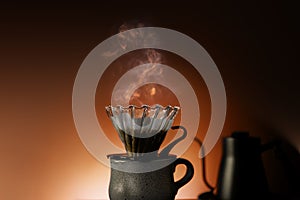 Coffee Drip Concept. Dripper, Mug and Kettle with Motion Steam. Dramatic lighting