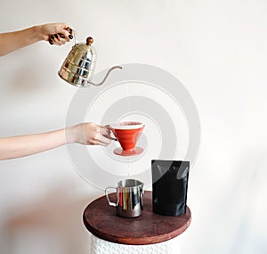 Coffee drip pour over aweigh in hands on white background