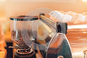 Coffee extraction from professional coffee machine, grinder closeup. Coffee shop closeup