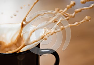 Coffee and foam splashing out of mug