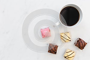 Coffee and French fondant cakes on white marble background