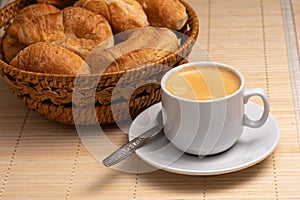 Coffee with fresh croissants in a wicker basket. Selective Focus