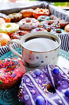 Coffee and frosted donuts with sprinkles