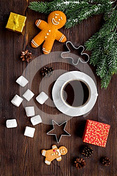 Coffee with gingebread cookies and gifts in christmas evening. Dark wooden background top view