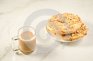 Coffee glass with two fresh dry biscuit with nuts /Coffee glass with two fresh dry biscuit with nuts on a white marble background