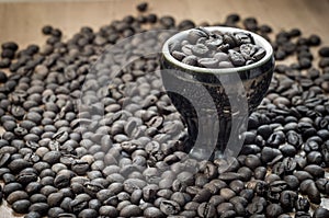 Coffee grain in a decorative cup. roasted coffee beans around.