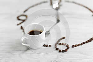 Coffee grains folded in the form of a clock on a wooden background. Instead of the number 7, a cup of coffee, which means it`s