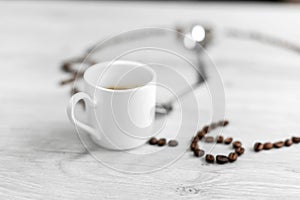 Coffee grains folded in the form of a clock on a wooden background. Instead of the number 7, a cup of coffee, which means it`s