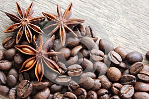 coffee grains and star anise on a wooden table, brown abstract background, warm texture, macro