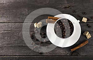 Coffee grains, sugar, cinnamon on dark wooden background