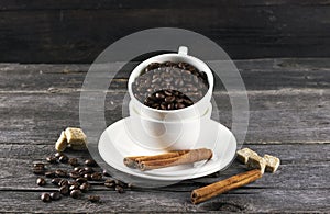 Coffee grains, sugar, cinnamon on dark wooden background