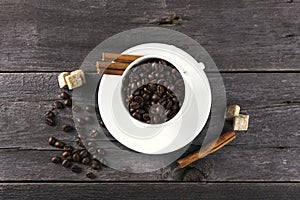 Coffee grains, sugar, cinnamon on dark wooden background
