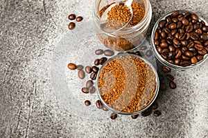 Coffee granules and coffee beans on background.