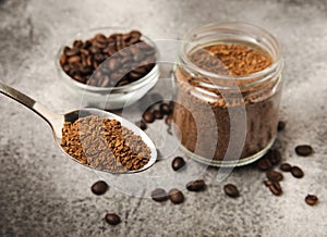 Coffee granules and coffee beans on background.