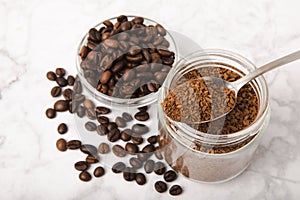 Coffee granules and coffee beans on background.