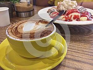 Coffee in a green cup with pancake with banana and ice-cream photo