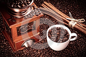 Coffee grinder with coffee cup and cinnamon sticks