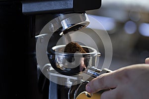 Coffee grinder grinding coffee pouring into a portafilter