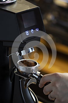 Coffee grinder grinding coffee pouring into a portafilter