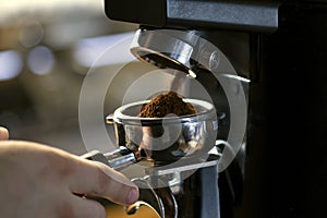 Coffee grinder grinding coffee pouring into a portafilter