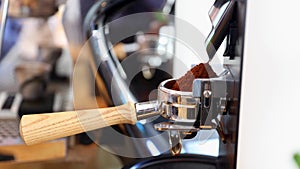 Coffee grinder grinds freshly coffee beans in a portafilter