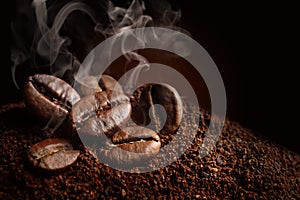 Coffee grounds and roasted beans on dark background, closeup