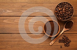 Coffee grounds and roasted beans on wooden table, flat lay. Space for text