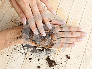 Coffee hand scrub with ground coffee on wooden background